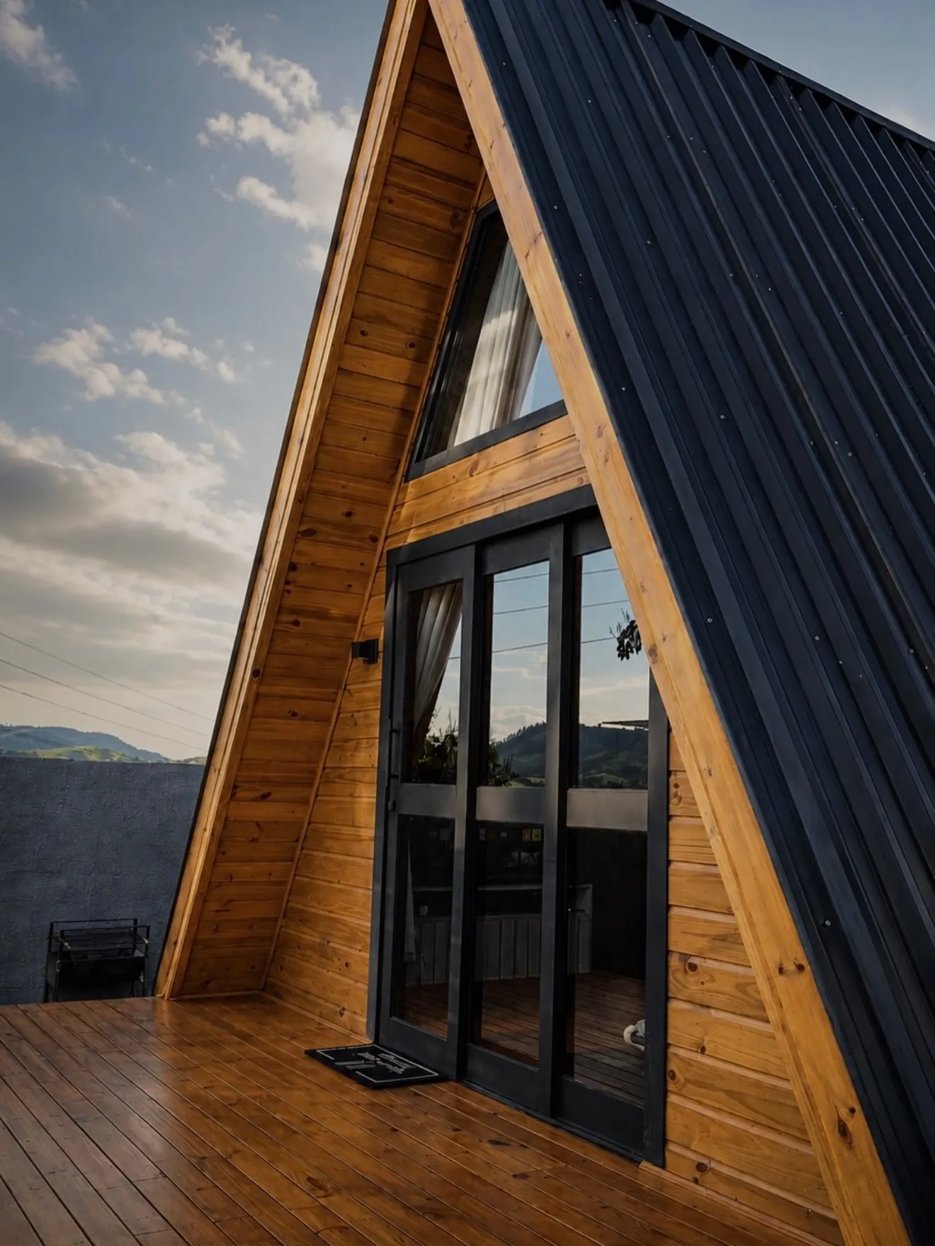 Detalhe frontal de chalé A-frame 321 Modular com revestimento em madeira