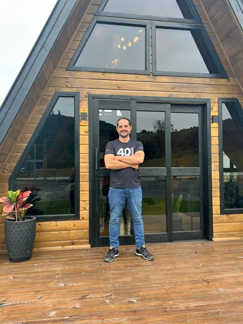 Tiago em frente a um chalé A-frame 321 Modular em Blumenau